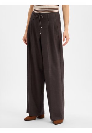 Wide-leg dark brown trousers with front pleats and a waist tie worn with a striped top and brown heeled shoes.