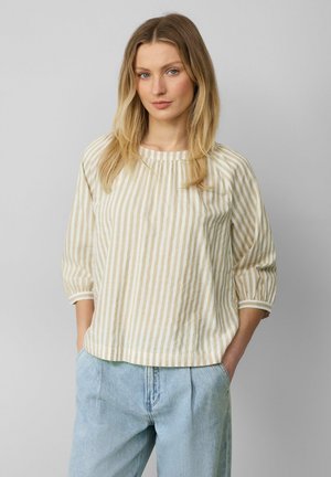 Gestreepte beige en witte blouse met een ronde hals, driekwartmouwen en een losse pasvorm, gecombineerd met lichtblauwe denim broek.