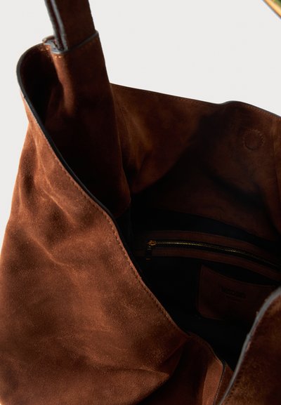 Καφέ σουέντ τσάντα χειρός με ανοιχτή κορυφή, που δείχνει μια εσωτερική τσέπη με φερμουάρ και μαλακή υφασμάτινη επένδυση.