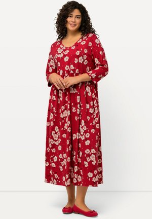 Robe florale rouge à manches trois-quarts, coupe décontractée, ornée de fleurs roses pâles et d'une jupe évasée. Portée avec des ballerines rouges assorties.