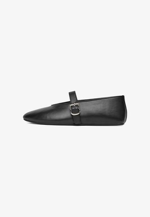 Pantof plat din piele neagră, cu vârful ascuțit și o singură curea fixată printr-o cataramă argintie, prezentat în profil lateral pe un fundal alb.