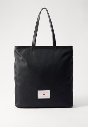 Sac cabas noir avec deux poignées et une plaque argentée portant l'inscription "LOVE MOSCHINO Made with Love" avec un petit cœur rouge.