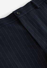Navy striped trousers made of textured fabric, featuring a button closure and flat front design, with subtle light-colored pinstripes.
