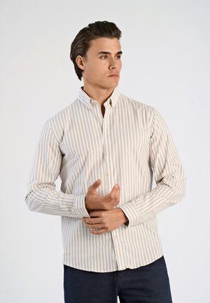 Beige and white striped long-sleeve shirt, button-up collar, cotton material, fitted design, with a curved hemline and buttoned cuffs.