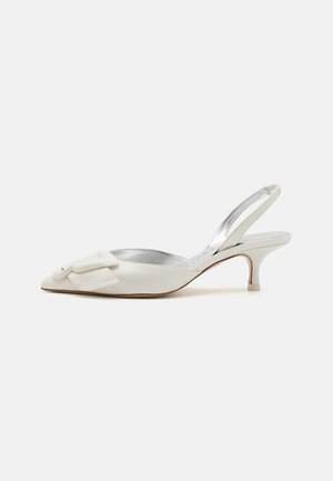 Slingback hakken van wit leer met een spitse neus, decoratieve strikdetails, zilveren voering en een slanke stiletto hak.