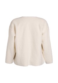 Kreemivalge väljavenitatava lõikega pehme tekstuurse kangaga pusa, langenud õlgade ja ümarate kaelusega. Vaade ainult tagant.