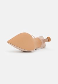 Beige podpatek s špičatou špičkou a minimalistickým páskem. Hladký svrchní materiál a texturovaná podešev s mírným podpatkem.