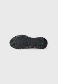 Čierny gumový podošva s drsným dezénom, s jemným zeleným akcentom a embosovaným logom Timberland.