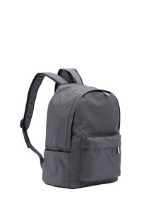 Grijze nylon rugzak met een ronde vorm, voorzien van verstelbare, gevoerde schouderbanden en een voorkant met een horizontale rits. Soepele textuur.