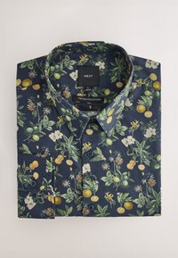 Marineblå skjorte med knapper og botanisk tryk med blomster, citrusfrugter og blade. Fremstillet af stof med en glat tekstur.