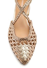 Zapato de tacón alto tejido en oro rosa metálico con punta afilada y correas entrelazadas. La superficie texturizada realza el detalle visual.