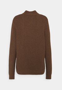 Maglione marrone lavorato a maglia con una texture a coste, maniche lunghe e colletto alto. Il design presenta una vestibilità rilassata e un colore uniforme.