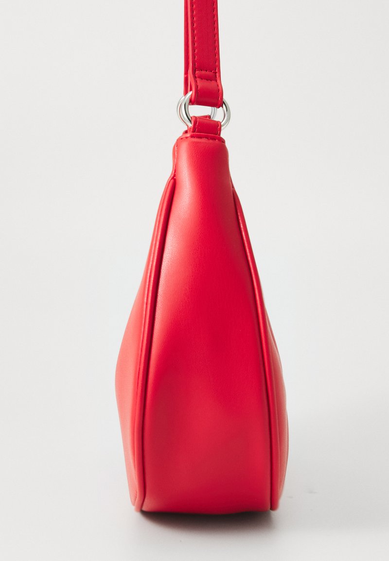 Bolso de mano de cuero rojo con una textura suave, forma triangular y una sola correa para el hombro. Presenta herrajes plateados en la correa.