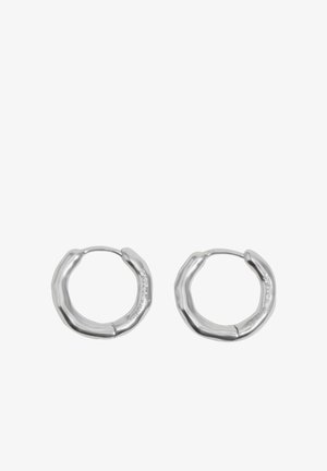 Pár náušníc v striebornej farbe s nepravidelným tvarom kruhov, hladkým lesklým povrchom a jemne vyrytým logom na vnútornej strane.