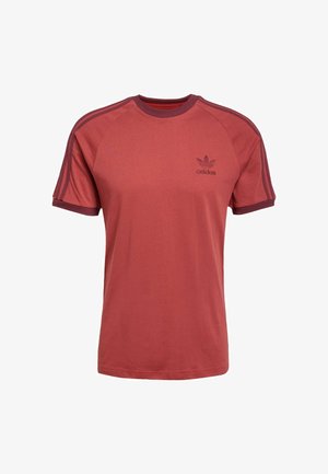 Red short-sleeve t-shirt made of cotton. Features crew neck, tonal three-stripe accents on shoulders, and embroidered Adidas logo.