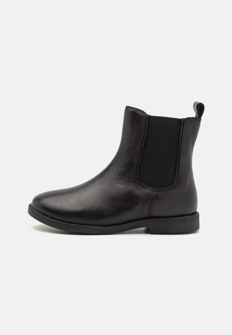 Bottine Chelsea en cuir noir avec empiècement latéral élastique et languette de maintien, semelle plate et bout arrondi, vue de profil sur fond blanc.