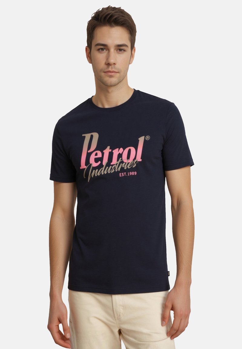 Mørkeblå bomulds t-shirt med "Petrol Industries" grafik i pink og beige. Korte ærmer, rund hals og glat tekstur.