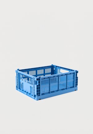 Caisse de rangement rectangulaire en plastique bleu avec côtés ventilés et poignées intégrées sur un fond gris clair uni.