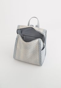 Rucsac din piele gri cu față din textil gri țesut, închidere cu fermoar, două mânere de sus și cusături detaliate pe margini. Buzunar interior cu fermoar vizibil.