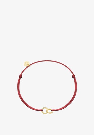 Bracelet en cordon rouge ajustable avec deux anneaux en or entrelacés et un petit charme rond en or attaché près du nœud.