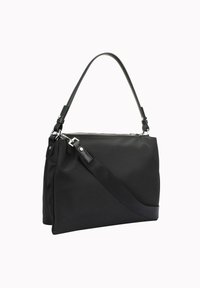 Črna najlon torbica z gladko teksturo, opremljena z zadrgo, nastavljivim ramenskim trakom in srebrnimi kovinskimi dodatki.