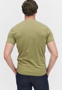 Olijfgroene, korte mouwen t-shirt met een ronde hals. Gladde textuur, aansluitend ontwerp, zonder zichtbare patronen of hardware details.