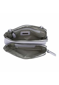 Bolso de cuero blanco con dos compartimentos, forrado en tela de rayas blancas y negras, con cierres de cremallera y asas planas.