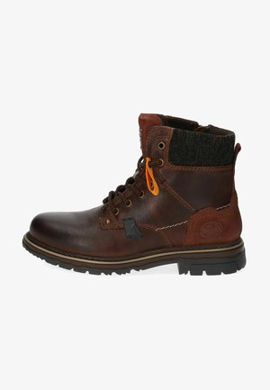 Bottine en cuir marron avec un col en textile foncé contrastant, œillets en métal, accent orange et semelle en caoutchouc noir robuste.