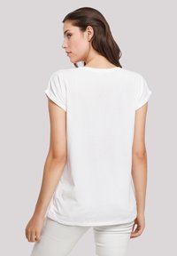 Weißes T-Shirt mit kurzen Ärmeln und umgeschlagenen Säumen, aus weichem Baumwollstoff, in lockerer Passform, mit rundem Ausschnitt und leicht abgerundetem Saum.