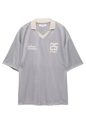Maillot de sport gris en tissu léger, avec des manches courtes, un col en V et des rayures verticales. Les accents comprennent le numéro "25" et "EXTRA CHANCE."