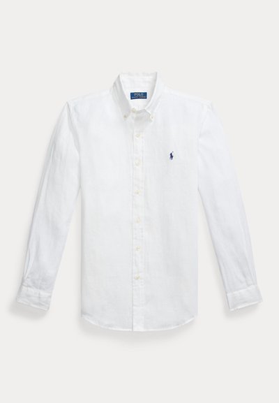 Bela lanena srajca z dolgimi rokavi in gumbi, s koničastim ovratnikom in izvezenim modrim logotipom na levem prsnem delu. Ima gumbe na manšeti.