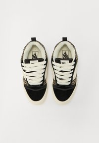 Sorte og brune sneakers med leopardmønster, hvide snørebånd og blødt indre for. Suede- og tekstilmaterialer skaber kontrasterende teksturer.