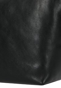 Borsa in pelle nera con superficie texture, angoli netti e forma strutturata, senza hardware o motivi visibili.