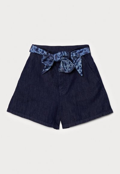 Τζιν σορτσάκια σε σκούρο μπλε χρώμα με φαρδύ λάστιχο, διακοσμημένα με ζώνη από υφασμάτινο σχέδιο δεμένη σε φιόγκο μπροστά. Ορατές δύο τσέπες στα πλάγια.