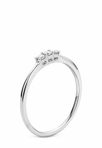 Sterling silver žiedas su glotna, lygia juosta; turi tris tolygiai išdėstytas ovalo formos skaidrias akmenis, įtvirtintus pakeltose grandinėlėse.