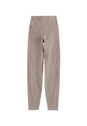 Leggings beige hechos de una tela elástica, con una cinturilla ancha y detalles de costura a lo largo de las piernas, diseñados para ofrecer comodidad y flexibilidad.