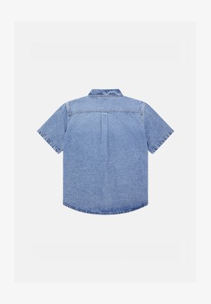 Camisa de mezclilla de manga corta en azul claro, con cuello clásico, detalle de yugo en la parte posterior y bajo curvado con acentos de costura.