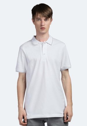 Polo bianco con colletto e pattina a tre bottoni, maniche corte, realizzato in un tessuto testurizzato e con sottili dettagli a contrasto.