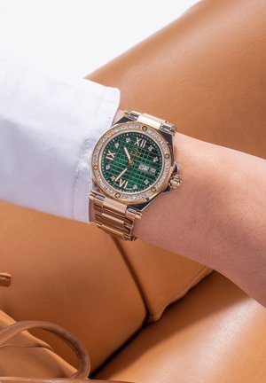 Orologio dorato con quadrante a motivo a griglia verde, accenti di diamante e display della data, con bracciale a maglia e forma di cassa octagonale.