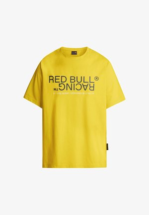 Kollane T-särk, millel on mustas paksus kirjas tekst "RED BULL RACING". Lühikesed varrukad, ümar kaelus, puuvilla segumaterjal, kantud tumedate teksastega.