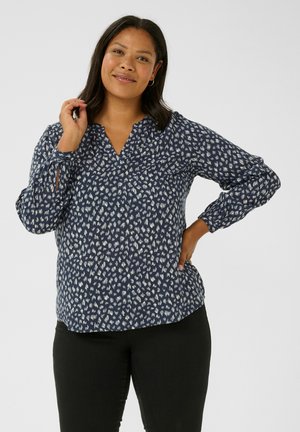 Blusa navy con scollo a V e maniche lunghe, caratterizzata da un motivo astratto bianco e dettagli con bottoni sulle maniche. Tessuto leggero con vestibilità comoda.