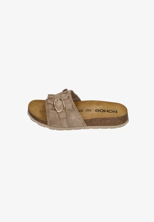 Beige slide sandal with a textured pastel suede upper, featuring a decorative buckle and a cork footbed with a flexible rubber sole.