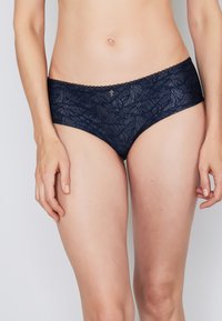 Navy blue lace panties featuring a leaf pattern, scalloped edges, and a small decorative gold accent at the front. Soft fabric texture.