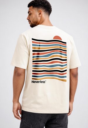 Man facing away, wearing a cream T-shirt with wavy colored stripes, a half sun, and "Neverless" printed on the back.