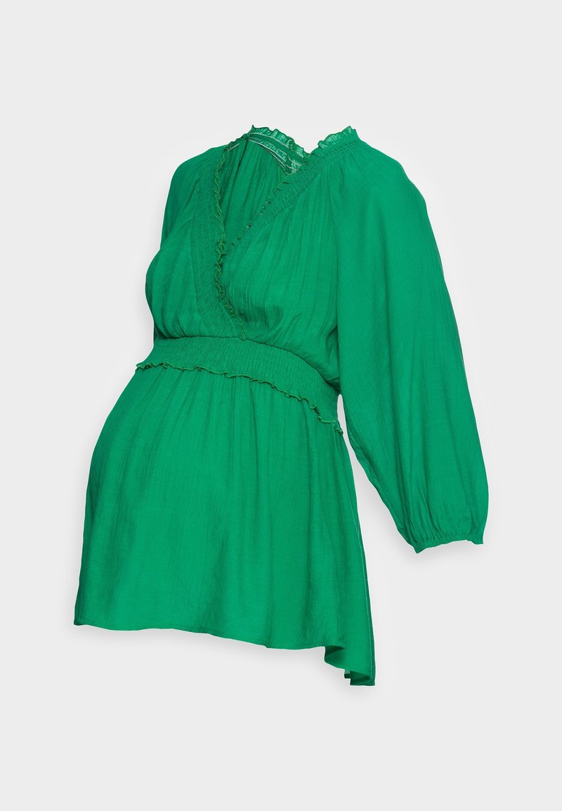 Blouse longue verte à manches longues avec décolleté en V, taille froncée, bord festonné et tissu texturé léger.