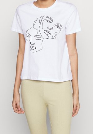 Hvid T-shirt med sort kontinuerlig linjekunst af to abstrakte ansigter, båret af en person med beige ribstrikkede bukser.