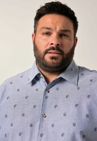 Camisa de botones azul claro hecha de una tela con una textura sutil, que presenta pequeños patrones de tazas bordados en azul marino y un cuello extendido.