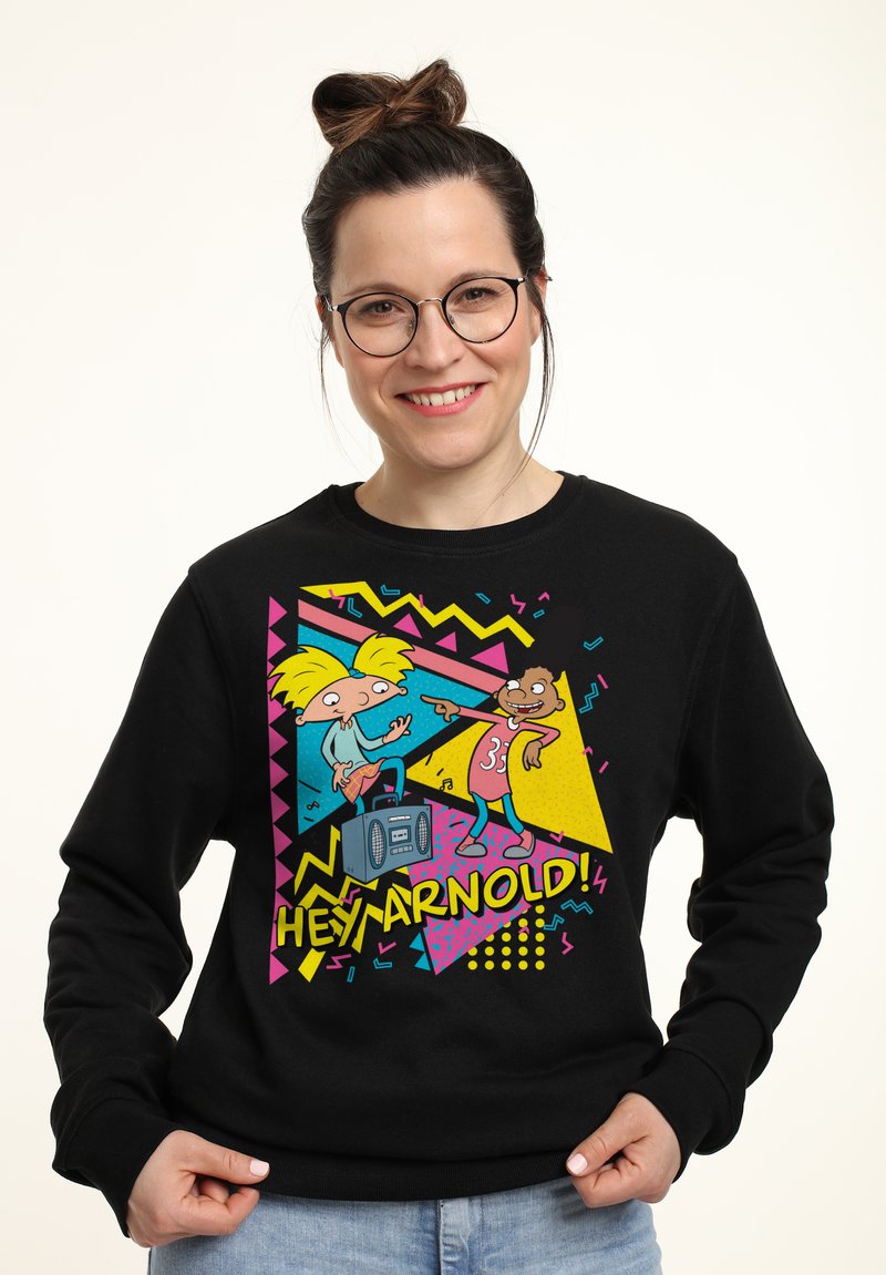 Sudadera negra con un gráfico colorido de dos personajes animados con un boombox. Incluye un texto en negrita que dice "¡HEY ARNOLD!" y patrones geométricos.