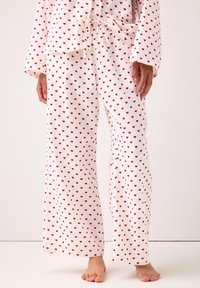 Hvid pyjamas sæt bestående af en top og bukser med et lille rødt hjerte mønster, letvægtsstof, løs pasform og en justerbar snor i livet.