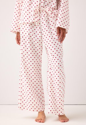 Set di pigiama bianco composto da una maglia e pantaloni con un piccolo motivo a cuori rossi, in tessuto leggero, vestibilità ampia e vita regolabile con cordoncino.